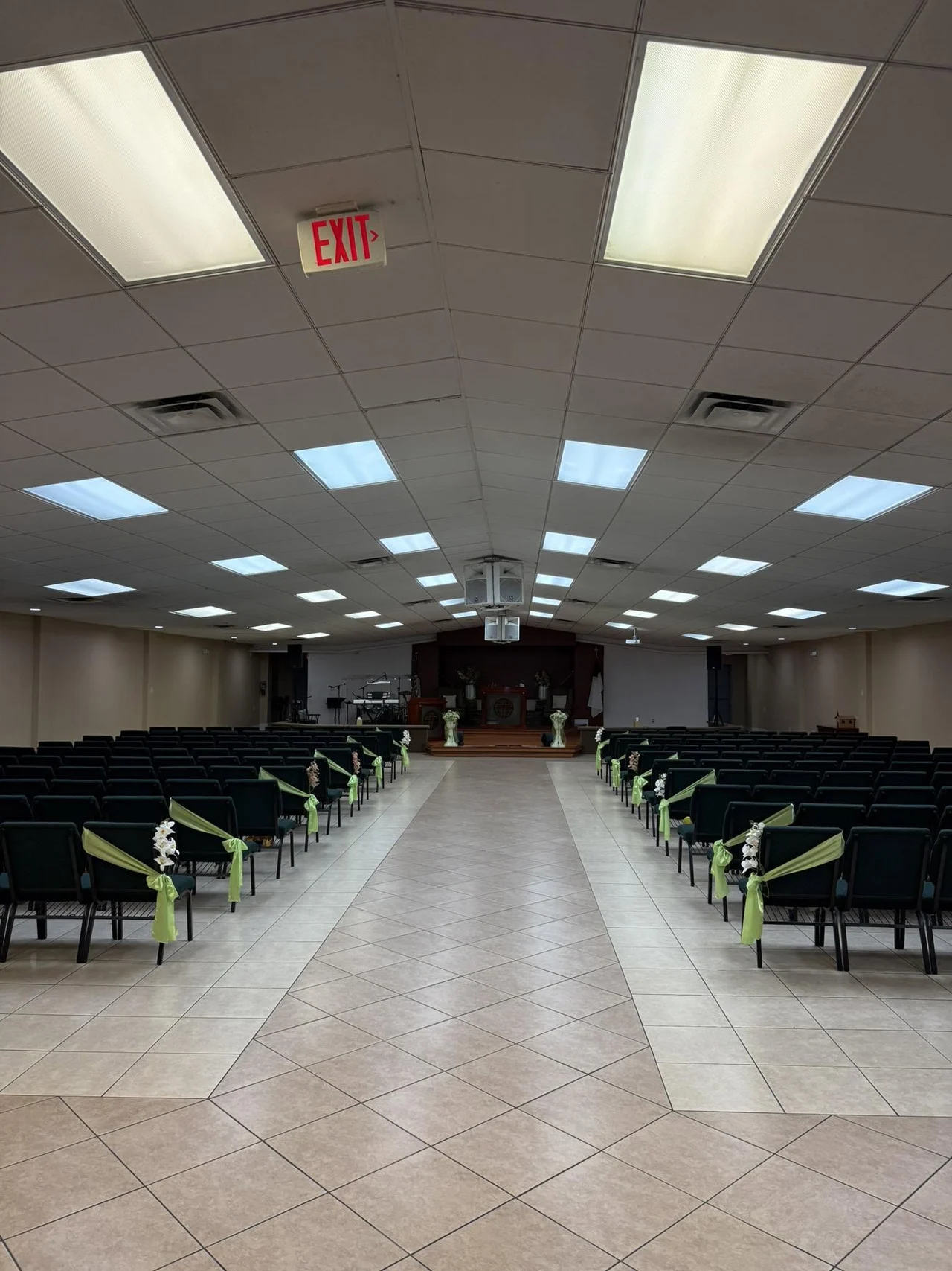 A large gathering space with rows of seating and a tiled center aisle