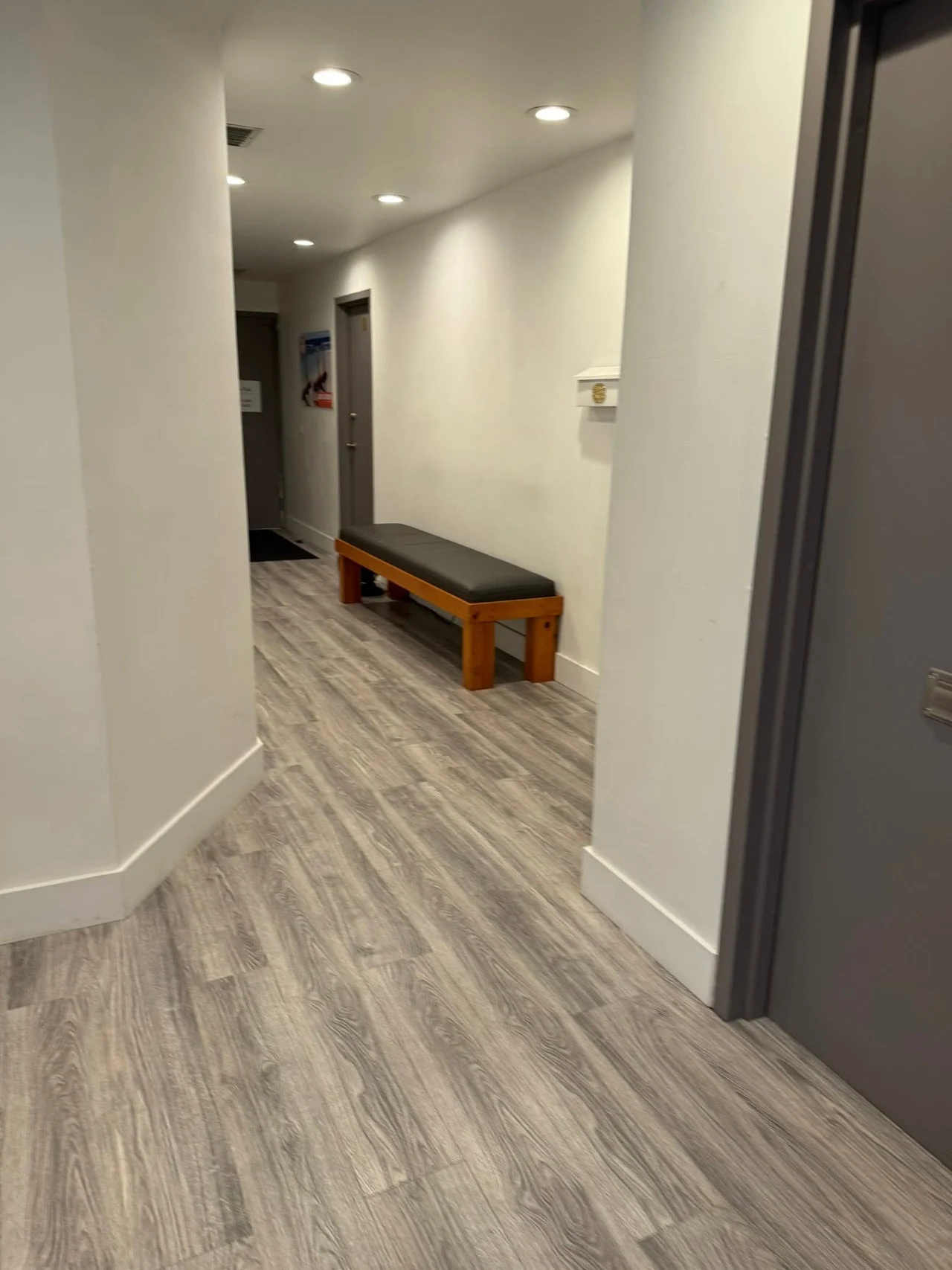 Customer property hallway with a wooden bench and clean wood-look flooring