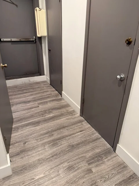 An interior entry with dark doors and wood-look flooring