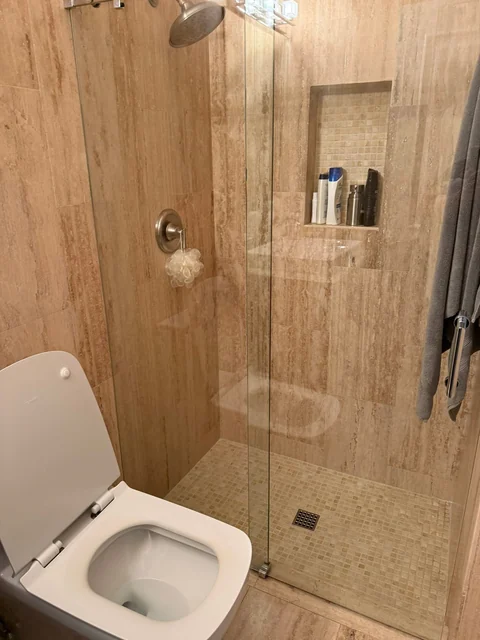 A glass shower enclosure, tiled walls, and bathroom fixtures