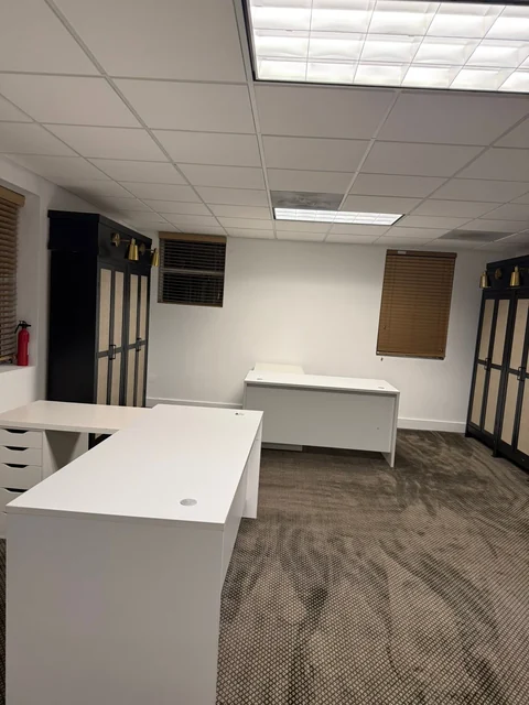 A customer office with white desks and dark storage cabinets