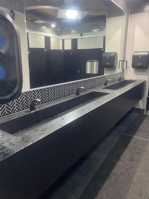 A commercial washroom with long counters and patterned tile