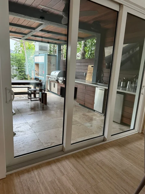 Glass patio doors opening toward a covered outdoor seating area